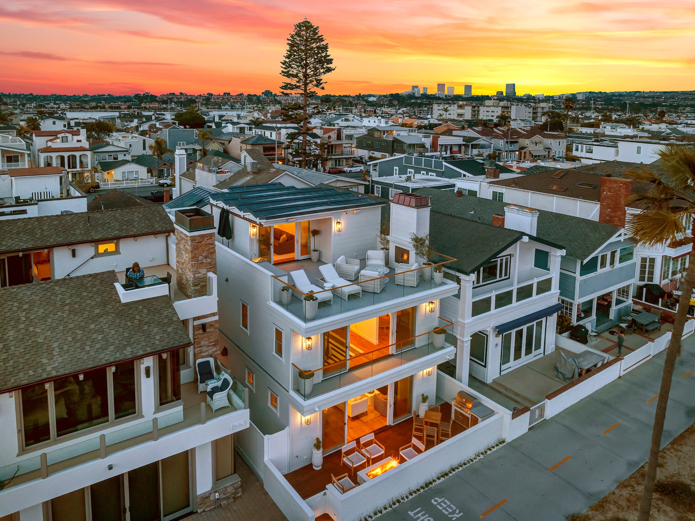 Three-story custom home with rooftop deck at sunset, Newport Beach Peninsula